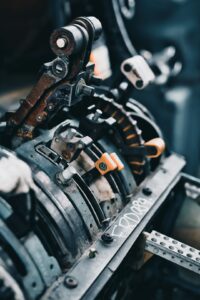 Technician operating a metal stamping machine to create precision parts in a factory setting.
