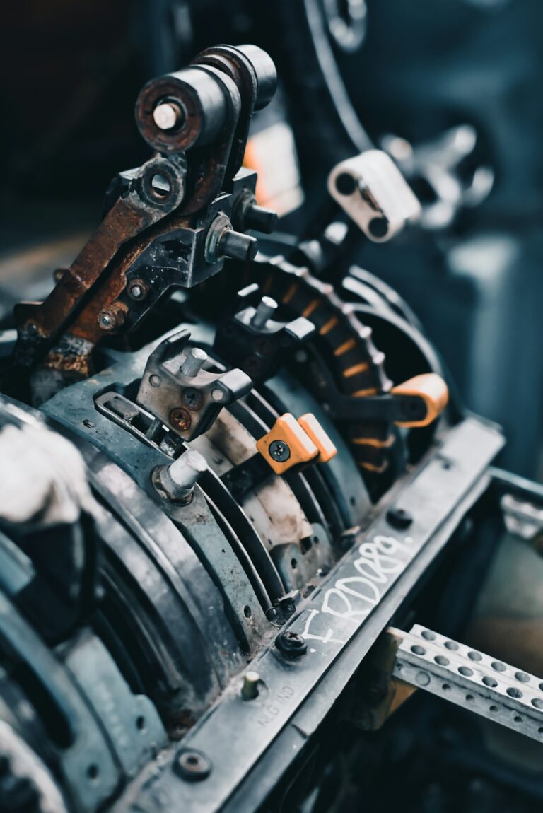 Technician operating a metal stamping machine to create precision parts in a factory setting.